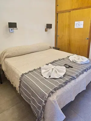 a bed with two white towels on top of it at Ribera Sur Hotel - Los Algarrobos - Tanti in Tanti