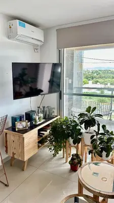 a living room with potted plants and a large flat screen tv at MD Amoblado Córdoba Capital in Cordoba