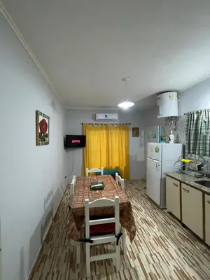 a small kitchen with a table and a refrigerator at Santa Martina in Merlo