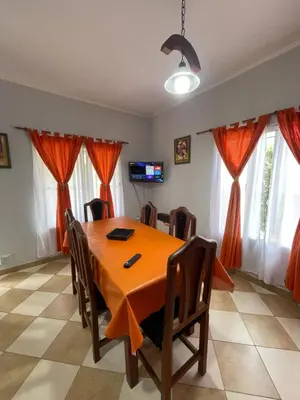 a dining room with a orange table and chairs at Santa Martina in Merlo
