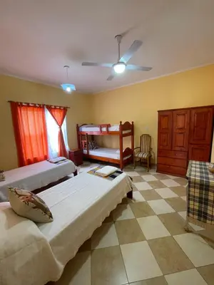 a bedroom with two beds and a table and a couch at Santa Martina in Merlo