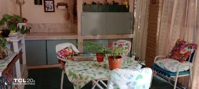 a small kitchen with a table and chairs with plants at Hospedaje LA LUCIA in Almafuerte