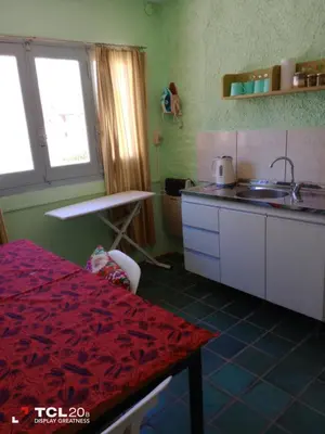 a kitchen with a red table and a sink at Hospedaje LA LUCIA in Almafuerte
