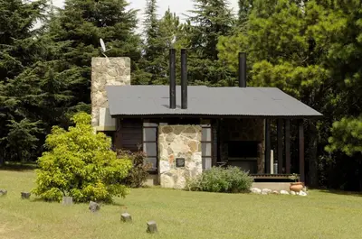 a small stone building with a black roof at Niderost in Villa Berna
