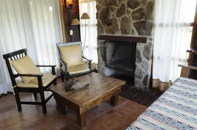 a living room with two chairs and a table and a fireplace at Niderost in Villa Berna