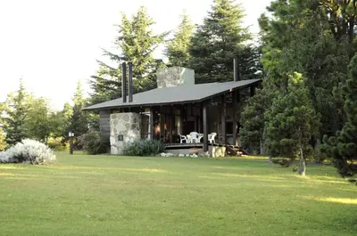 a stone house with a porch on a lawn at Niderost in Villa Berna