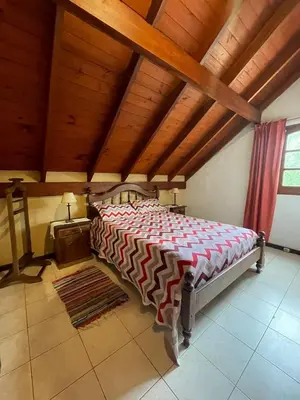 a large bed in a room with a wooden ceiling at Loma Dorada Cabañas in Villa General Belgrano