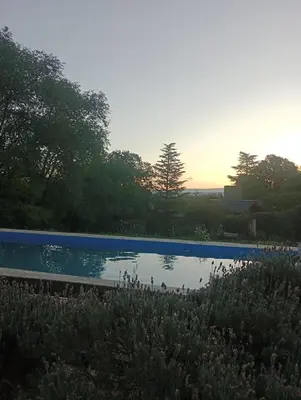 a swimming pool with a sunset in the background at Loma Dorada Cabañas in Villa General Belgrano
