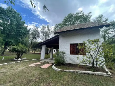 a small white building with a window in a yard at Loma Dorada Cabañas in Villa General Belgrano