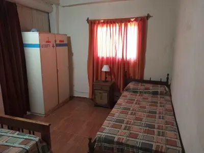 a bedroom with two beds and a dresser and a window at Depto Santo Brochero centro in Villa Cura Brochero