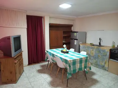 a kitchen with a table with chairs and a television at Depto Santo Brochero centro in Villa Cura Brochero