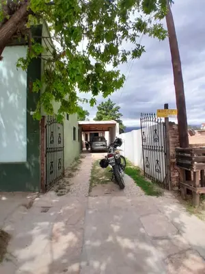 a motorcycle parked next to a house with a gate at Depto Santo Brochero centro in Villa Cura Brochero