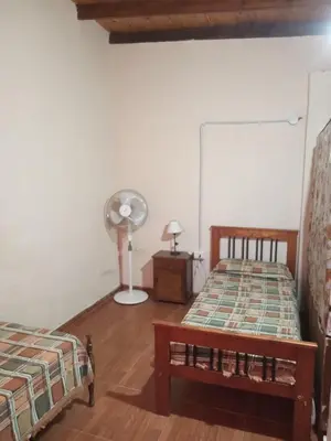 a bedroom with two beds and a fan at Depto Santo Brochero centro in Villa Cura Brochero