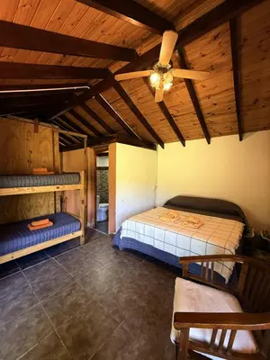 a bedroom with a bed and a ceiling fan at El Camino Cabañas y Apart in Villa Berna