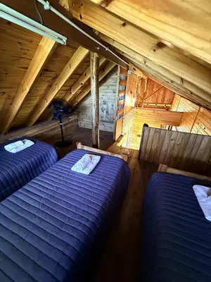 a room with two beds in a attic at El Camino Cabañas y Apart in Villa Berna