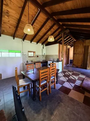 a dining room with a wooden table and chairs at El Camino Cabañas y Apart in Villa Berna