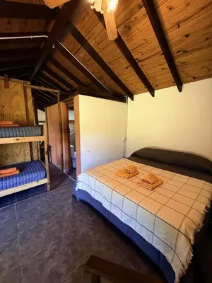 a bedroom with a large bed and a wooden ceiling at El Camino Cabañas y Apart in Villa Berna