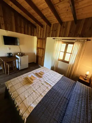 a bedroom with a bed in a wooden room at El Camino Cabañas y Apart in Villa Berna