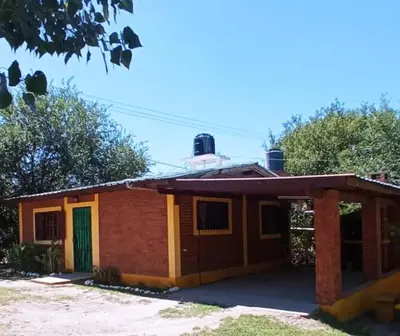 a small house with a green door in front of it at Granate in Villa Cura Brochero
