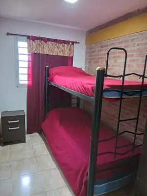 two bunk beds in a room with a brick wall at Granate in Villa Cura Brochero