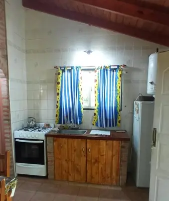 a kitchen with a stove and a sink and a window at Granate in Villa Cura Brochero