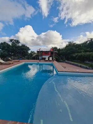a large swimming pool with a house in the background at VILLA ESPINA CHALET DE MONTAÑA a 8 km de San Javier in Villa de Las Rosas