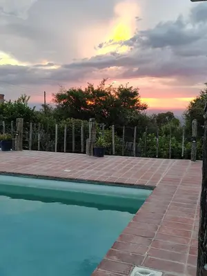 a swimming pool with a sunset in the background at VILLA ESPINA CHALET DE MONTAÑA a 8 km de San Javier in Villa de Las Rosas
