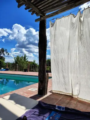 a white curtain next to a swimming pool at VILLA ESPINA CHALET DE MONTAÑA a 8 km de San Javier in Villa de Las Rosas