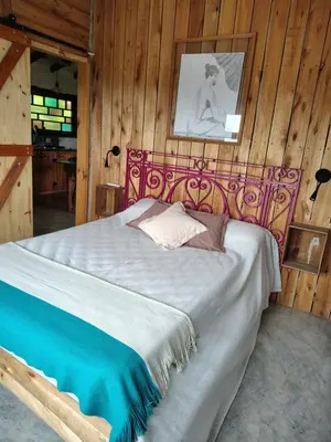 a bedroom with a bed in a wooden wall at VILLA ESPINA CHALET DE MONTAÑA a 8 km de San Javier in Villa de Las Rosas