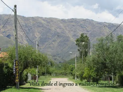 a mountain in the distance with a road and trees at Cabañas El Maiten in Merlo
