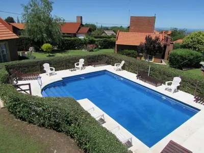 a large swimming pool with chairs at Cabañas El Maiten in Merlo