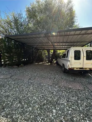 a white van parked under a covered area at Cabañas El Maiten in Merlo