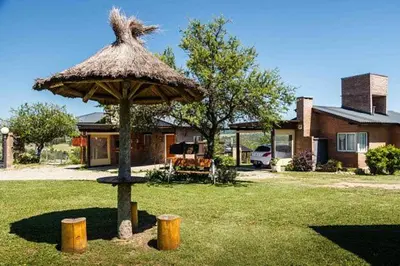 a large umbrella in the yard of a house at Cabañas & Suites Vista Hermosa in Los Reartes