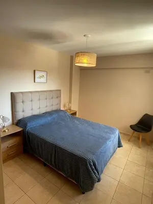 a bedroom with a blue bed and a chair at Bv San Juan - Nva Cba in Cordoba