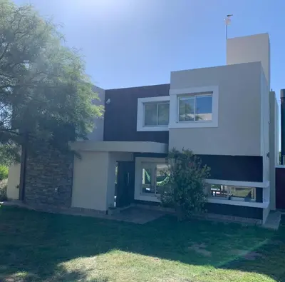 a house with a white door and a tree at Tierra Alta, Comarca Serrana in Cordoba