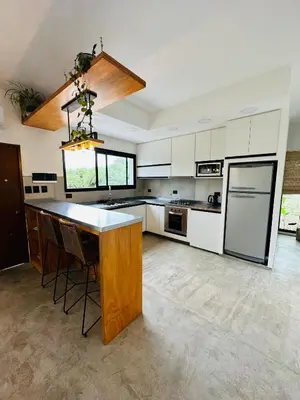 a large kitchen with white cabinets and a large island at Casa Simona in Las Rabonas