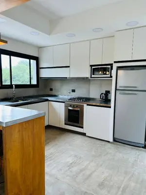 a kitchen with white cabinets and a refrigerator at Casa Simona in Las Rabonas