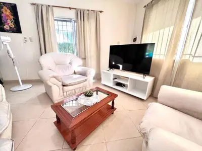 a living room with a tv and chairs and a coffee table at Hermosa y amplia casa con pileta in San Antonio de Arredondo