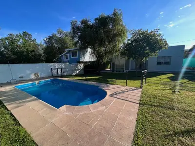 a swimming pool in the backyard of a house at Hermosa y amplia casa con pileta in San Antonio de Arredondo