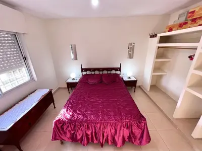 a bedroom with a large red bed and two benches at Hermosa y amplia casa con pileta in San Antonio de Arredondo