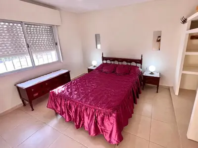 a bedroom with a large bed with a red bedspread at Hermosa y amplia casa con pileta in San Antonio de Arredondo