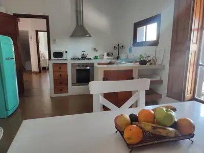 a kitchen with a table with a bowl of fruit on it at El depto de Bowie in Santa Rosa de Calamuchita