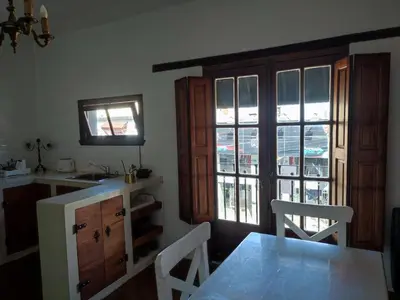 a kitchen with a table and chairs and a window at El depto de Bowie in Santa Rosa de Calamuchita