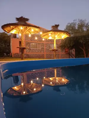 a reflection of a table and umbrellas in a pool at La Casa de Piedra in Villa Santa Cruz del Lago