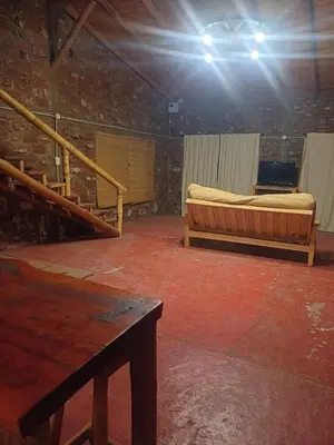 a room with a bed and a staircase in a building at La Casa de Piedra in Villa Santa Cruz del Lago