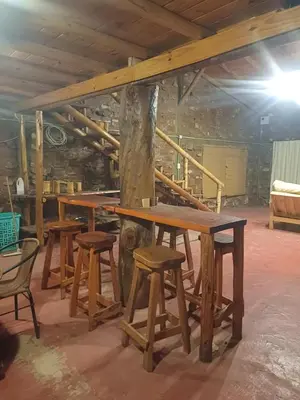 a group of tables and stools in a room at La Casa de Piedra in Villa Santa Cruz del Lago