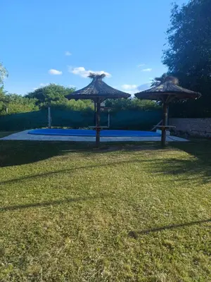 two straw umbrellas sitting in a grass field at La Casa de Piedra in Villa Santa Cruz del Lago
