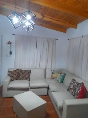 a living room with a white couch and a chandelier at rafaella in Villa Anizacate