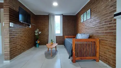 a bedroom with a bed and a brick wall at Cabañas Estancia del Pilar - Cabañas de montaña in Estancia Vieja