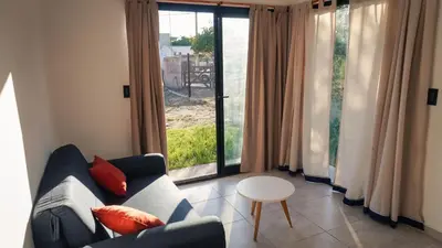 a living room with a couch and a table and windows at Complejo Giraluna in Almafuerte